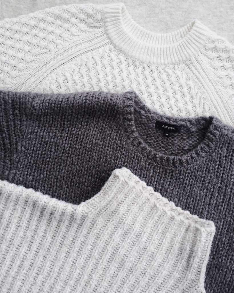 three white and grey wool sweaters